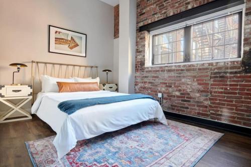 een slaapkamer met een bed en een bakstenen muur bij Spacious 4bed Loft Downtown Boston Beacon Hill in Boston