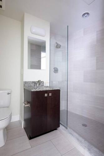 a bathroom with a shower and a toilet and a sink at Wonderful FIDI 2br with Keyless Entry in Boston
