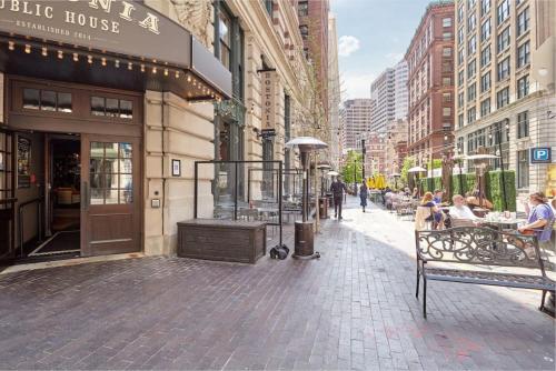 a city street with people sitting at tables outside a building at Wonderful FIDI 2br with Keyless Entry in Boston
