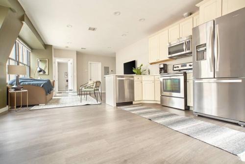 a large kitchen with stainless steel appliances and a bed at Luxurious 1BR in FIDI Boston Close to Everything in Boston