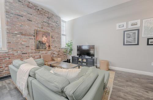 a living room with a couch and a brick wall at Lavishly Designed Home With Office Close to T in Boston