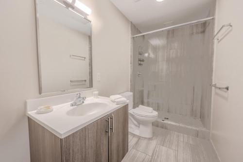 a bathroom with a sink and a toilet and a shower at Lavishly Designed Home With Office Close to T in Boston