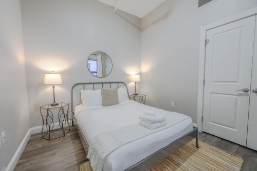 a white bedroom with a bed and a mirror at Pet Friendly Downtown Boston Elevator Washer Dryer in Boston