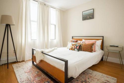 a bedroom with a bed with white sheets and pillows at Delightful Downtown Boston 2bed 2bath Apartment in Boston