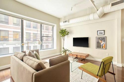 a living room with a couch and a tv at 2br 2ba FIDI Apt Keyless Entry Walk anywhere in Boston