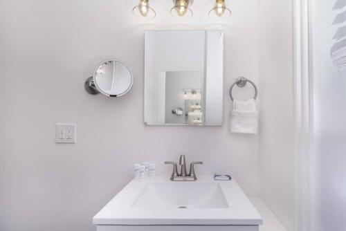 a white bathroom with a sink and a mirror at Cozy Central Fenway Studio in Boston