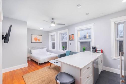 a white living room with a couch and a table at Cozy Central Fenway Studio in Boston