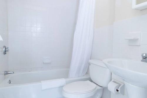a white bathroom with a toilet and a sink at Fantastic 1BR Apt in Financial District, Boston in Boston