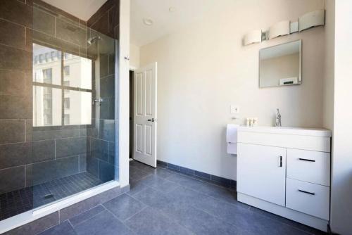 a bathroom with a shower and a sink and a mirror at Spacious FIDI 2br 2ba Close to Everything in Boston