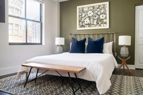 ein Schlafzimmer mit einem großen Bett mit blauen Kissen in der Unterkunft Lovely FIDI Studio Close to Faneuil Hall in Boston