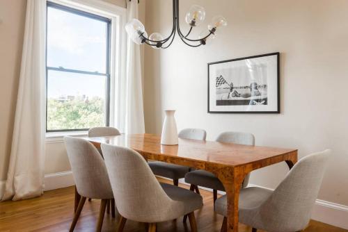 a dining room with a wooden table and chairs at Luxury 4BR 3BA in Fenway w Epic Roof Deck in Boston