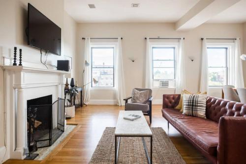a living room with a couch and a fireplace at Luxury 4BR 3BA in Fenway w Epic Roof Deck in Boston