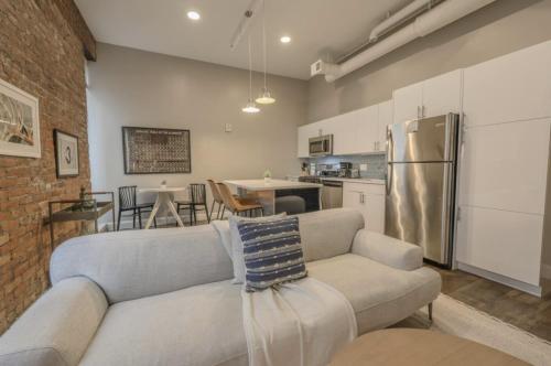 a living room with a couch and a kitchen at Downtown Designer Home Keyless Washer and Dryer in Boston