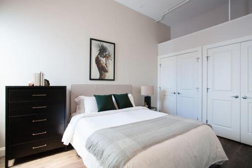 ボストンにある4 bed Loft Steps to Boston Common Beacon Hillのベッドルーム1室(大型ベッド1台、黒いドレッサー付)