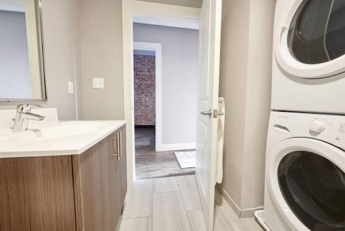 a bathroom with a sink and a washing machine at Pet Friendly 3 Bed 2 Bath steps to Beacon Hill in Boston