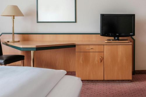 a hotel room with a television on a desk at FOUR Essen City Centre in Essen
