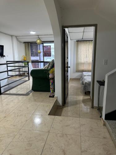 a living room with a green couch on a tile floor at Alojamientos por aeropuerto villa olímpica estadio expofuturo in Pereira