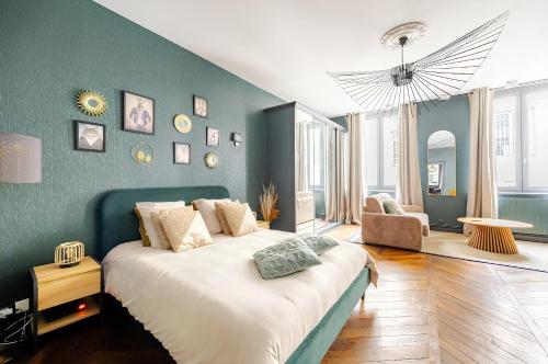 a bedroom with a large bed and a blue wall at Nancy Vieille Ville Stanislas in Nancy