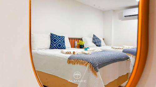 a mirror reflecting two beds in a bedroom at Flat FM20 Cabo Branco Stilo - By Almare in João Pessoa