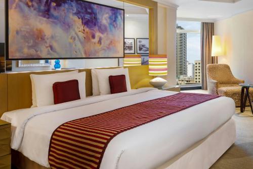a bedroom with a large bed with a large painting at Gulf Hotel Bahrain Convention and SPA in Manama