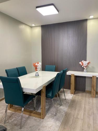 ナイロビにあるIndesign makumbi park, Muthama acces road 2-bedroom apartmentのカンファレンスルーム(白いテーブル、青い椅子付)