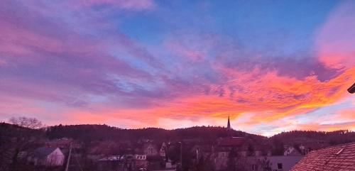 a colorful cloudy sky at sunset in a city at Złoty Trakt pokoje i rowery in Złoty Stok