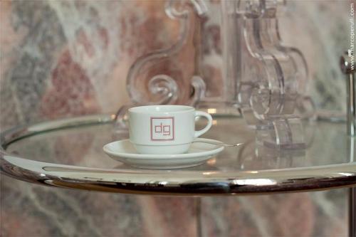 una taza de café y un platillo sobre una mesa de cristal en Palazzo De Giorgi B&B, en Lecce