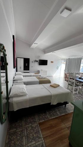 a group of four beds in a room at Pousada Minha Casa- Aconchegante no Centro de São Lourenço in São Lourenço