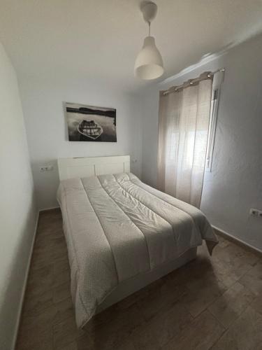 Un dormitorio con una cama en una habitación blanca. en Las Manuelas, en Arcos de la Frontera