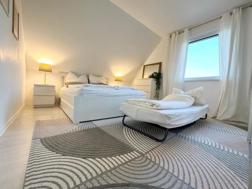 Dormitorio blanco con 2 camas y alfombra en Trave Resort Ferienhaus, en Schackendorf