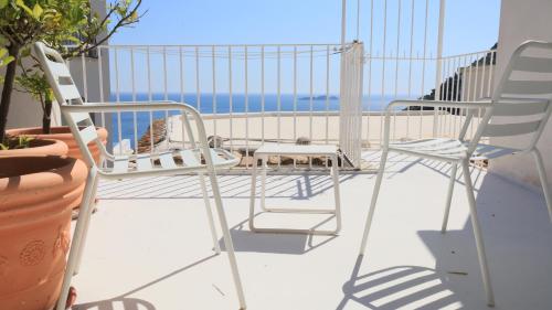 a balcony with two chairs and a table at Love in Blue - La Terrazza di Positano in Positano