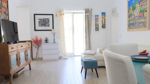 a living room with a couch and a table at Love in Blue - La Terrazza di Positano in Positano