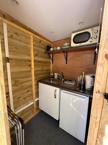 a small kitchen with a sink and a microwave at Alnmouth Glamping in Alnmouth