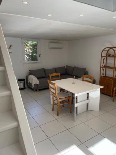 un salon avec une table et un canapé dans l'établissement Location maison vacances T3, à Gruissan