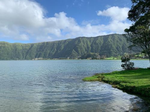 a large body of water with mountains in the background at Sete Cidades House in Sete Cidades