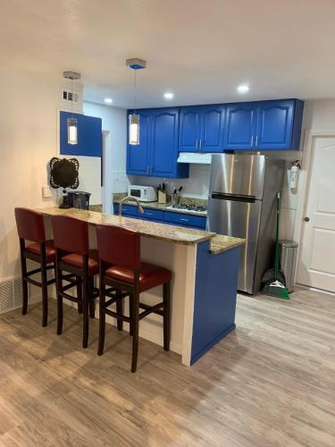 a kitchen with blue cabinets and a counter with chairs at Casa De Colores - Airport - Fiesta Tx - The Pearl in San Antonio