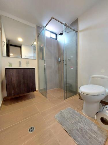 a bathroom with a toilet and a glass shower at Acogedor y central Apartamento ! in Pasto