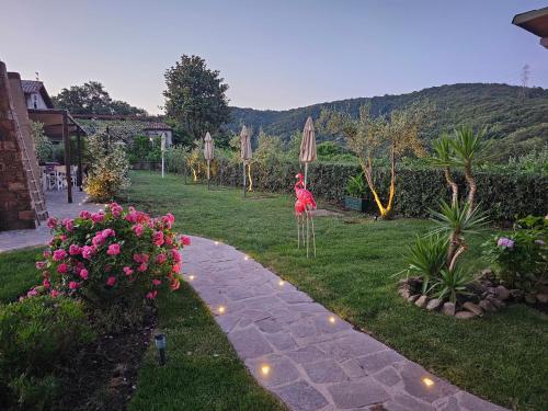 a garden with a woman in a dress and some flowers at Almanuda - Naturist Village - Adults Only in Sutri
