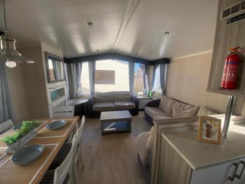 a living room with a couch and a table at Lovely 6 Berth Caravan At Ty Mawr Holiday Park, North Wales Ref 86004K in Conwy