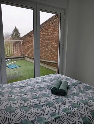 une chambre avec un lit avec deux oreillers dessus dans l'établissement Le petit nid Béthunois, à Béthune