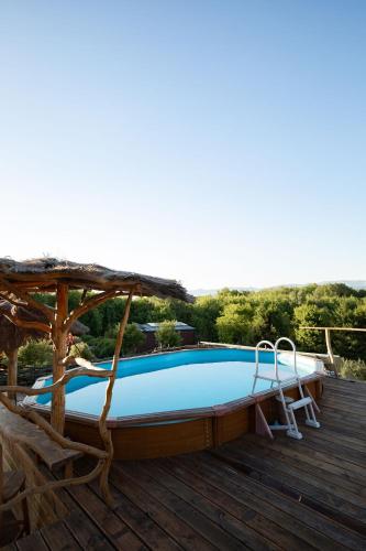 a pool on a deck with a umbrella and two chairs at Bonaluti Adults - Azyl Dla Dorosłych in Mirsk