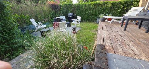 a deck with two white chairs and a table and benches at Comfortable Apartment in Waterloo with Jacuzzi - 78m² in Waterloo