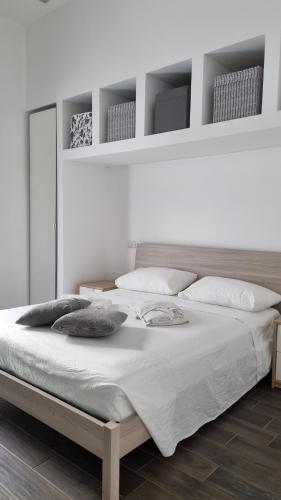 Un dormitorio con una cama grande con sábanas y almohadas blancas. en Dimora Vanessa, en Brindisi