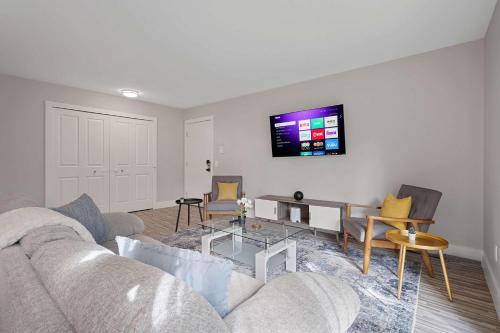 a living room with a couch and a tv on the wall at Serene & Modern Haven for Relaxation in Rochester Hills