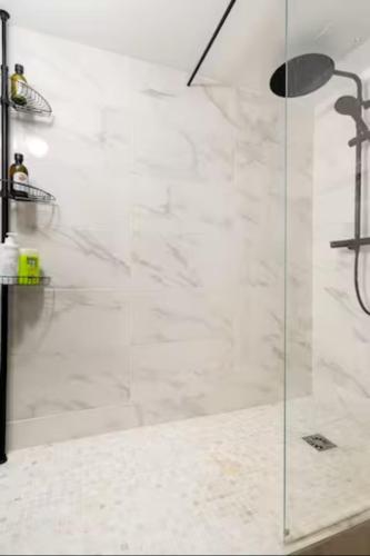 une douche avec une porte vitrée dans une salle de bain dans l'établissement Paris 9e Loft, à Paris