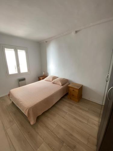 une chambre blanche avec un lit et une fenêtre dans l'établissement Charmant 3 pieces en bord de mer et proche tramway, à Nice