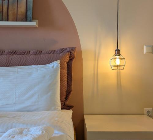 a bedroom with a bed with a light on the wall at Althea Apartments in Katakolon