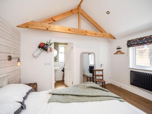 een slaapkamer met een wit bed en een bureau bij Garden Cottage, Cosy, Private, Short drive to beach in North Walsham