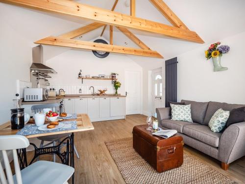 een woonkamer met een bank en een tafel bij Garden Cottage, Cosy, Private, Short drive to beach in North Walsham