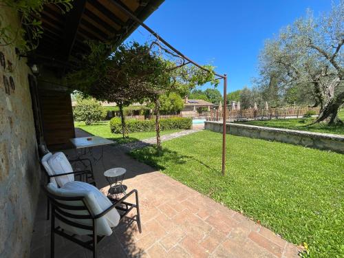 a patio with two chairs and a table in a yard at Agriturismo Eco-Bio Villa Vacasio in Pitigliano
